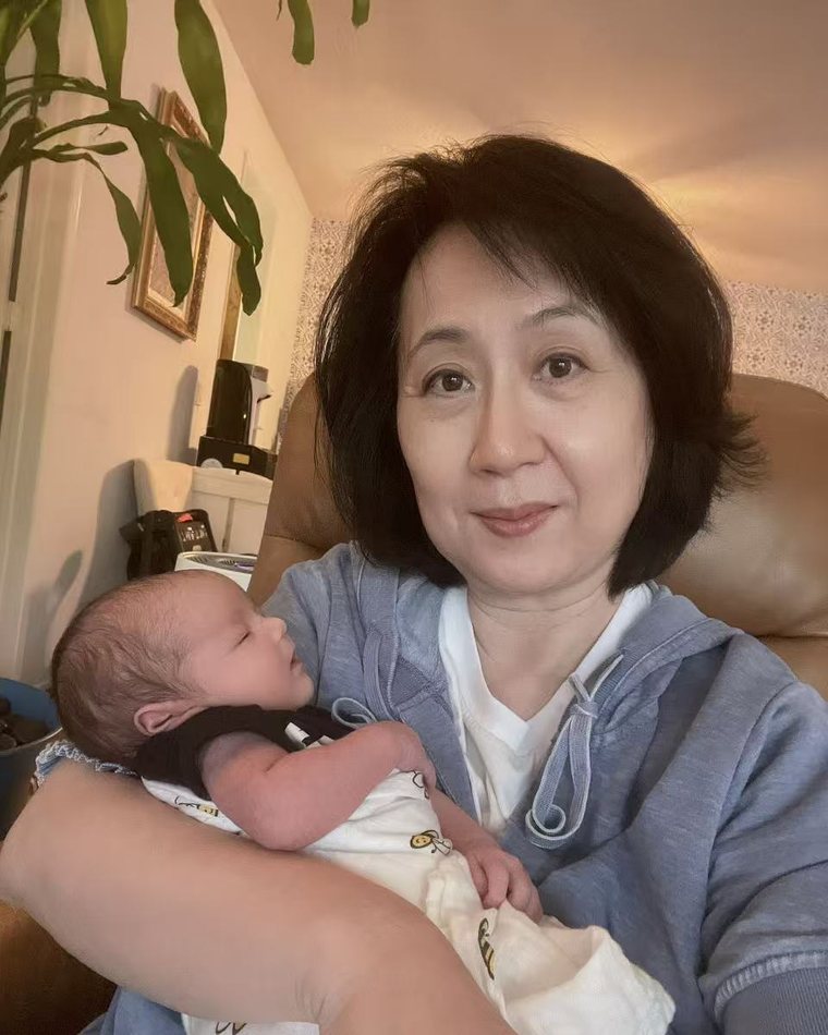 Cathie Li holding a sleeping newborn in her arms